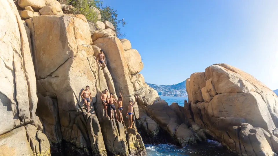 Clavadistas sobre las rocas de una caleta en Acapulco