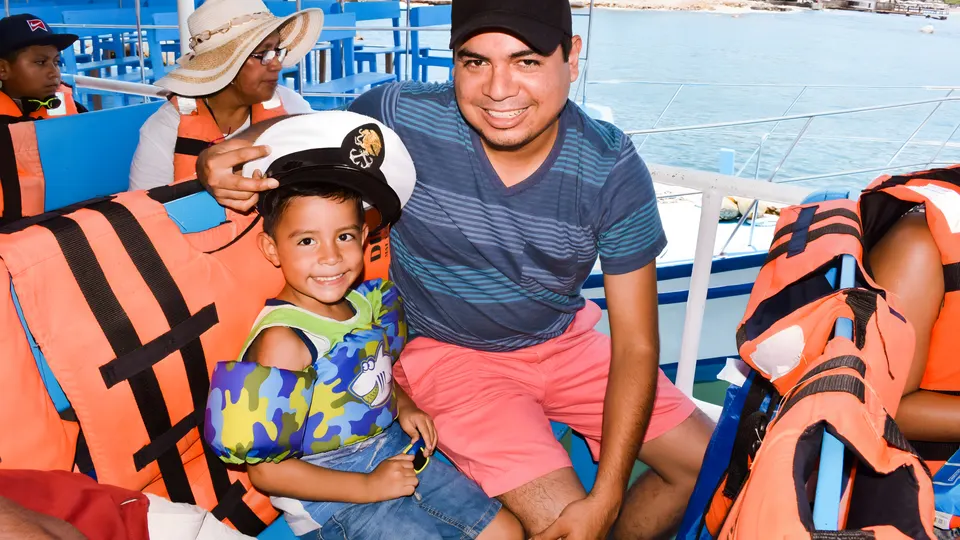 Familia con niño y chalecos salvavidas en el paseo en yate de Acapulco