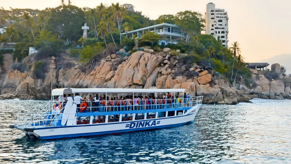 Yate de Yates Dinka recorriendo las rocas y casas frente al mar de Acapulco